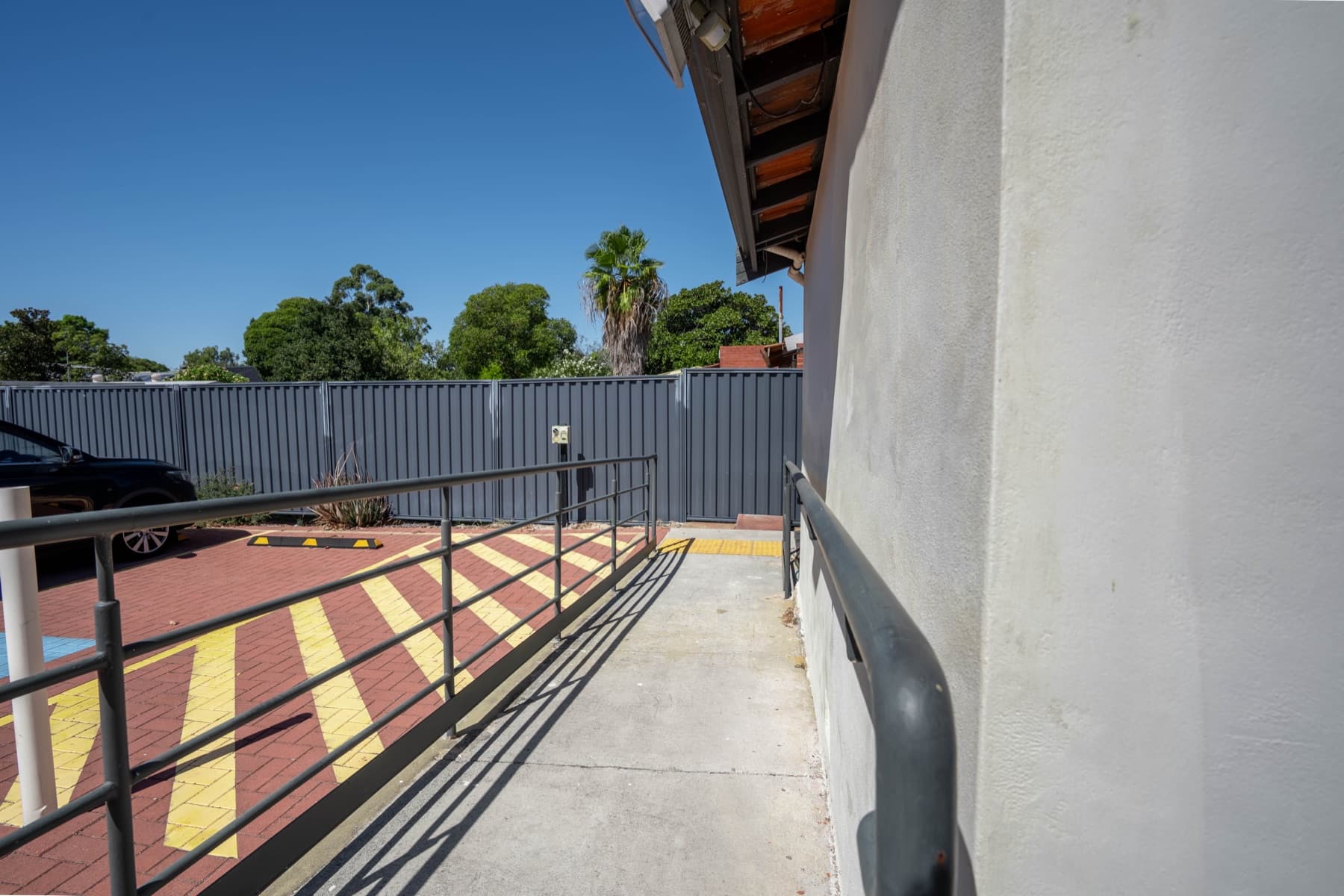 Wheelchair ramp with handrails leading to the clinic entrance
